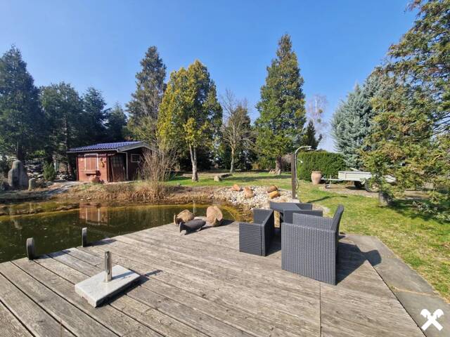 Immobilie in Oberzögersdorf - TRAUMHAFTER BUNGALOW FÜR ZWEI PERSONEN SAMT NEBENGEBÄUDE FÜR HOBBYRAUM, PARKÄHNLICHEM GARTEN MIT SCHWIMMTEICH ALS NATURPOOL DIREKT AN FELDER DER REGION ANGRENZEND - Bild 2